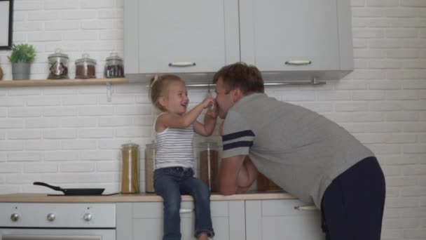 Schattige vader en dochter knuffelen in de ochtend in de keuken — Stockvideo