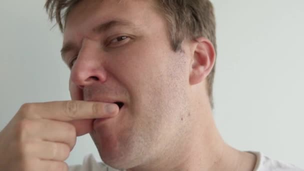 Ein Mann isst eine weiße Pille und trinkt sie mit Wasser — Stockvideo