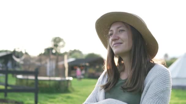 Close-up de uma mulher bonita em um chapéu ao pôr do sol . — Vídeo de Stock