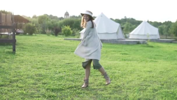 Beautiful woman farmer in a hat is dancing at sunset — Stock Video