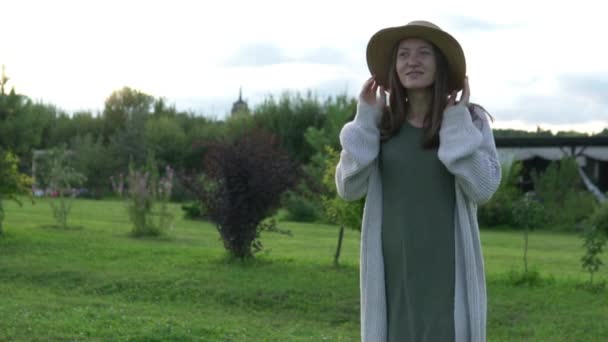 A beautiful woman walks on a farm on a cool summer evening — Stock Video