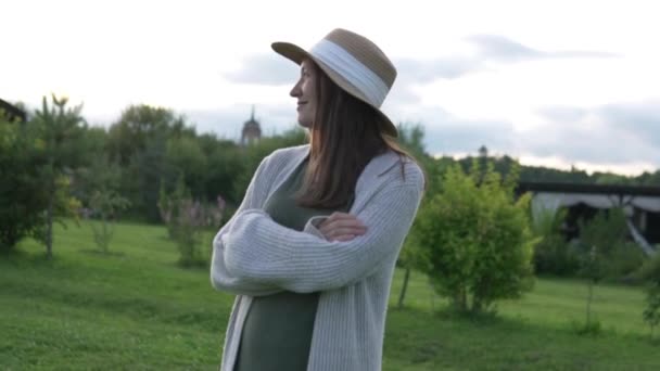 帽子をかぶったスタイリッシュな女性農家が夏に歩く — ストック動画