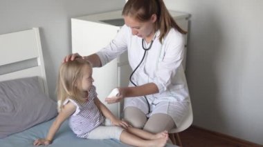 Doktor sıcaklığı elektronik termomete ile ölçer.