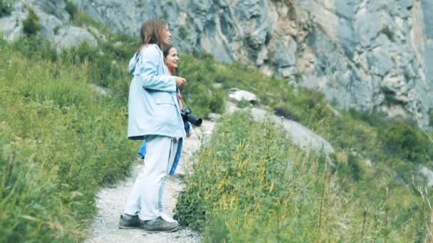 Une femme dans les montagnes regarde un beau paysage — Video