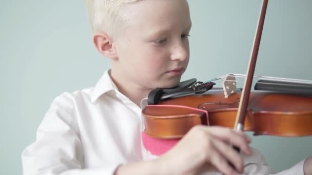 Ένα παιδί μαθαίνει να παίζει βιολί σε μουσικό σχολείο. — Αρχείο Βίντεο