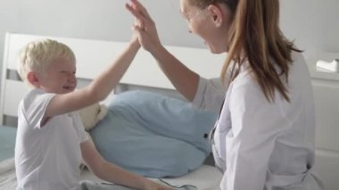 Doktor iyileşen çocuk hastayı tebrik ediyor.