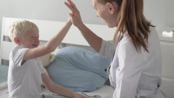 El médico felicita al niño paciente con la recuperación — Vídeos de Stock