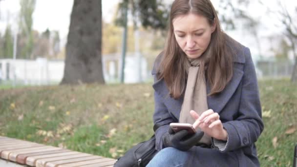 Mulher leva o dedo na tela de um telefone celular — Vídeo de Stock