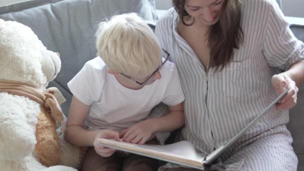 Mutter und Sohn schauen sich seine Kinderfotos an — Stockvideo