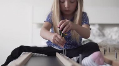 Güzel küçük bir kız tornavidayla cıvata çeviriyor.. 