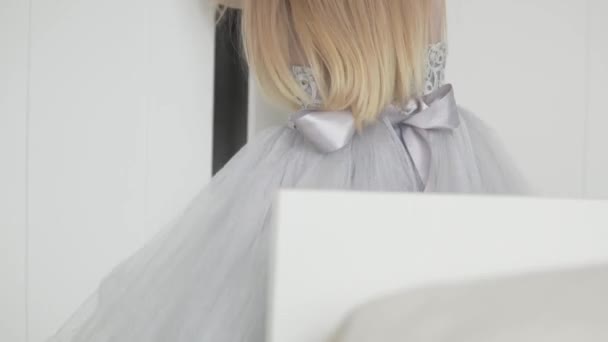 Una niña con un vestido elegante y curvilíneo se mete en un armario — Vídeo de stock