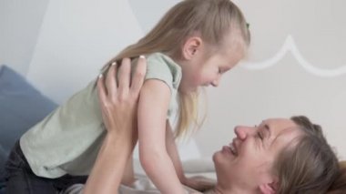 Mutlu anne ve tatlı küçük kız gülüyor.