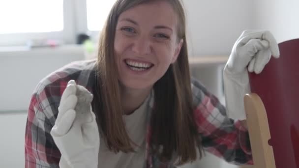 Müde, fröhliche Frau in Handschuhen trägt einen Kinderstuhl und zeigt einen schmutzigen Lappen — Stockvideo