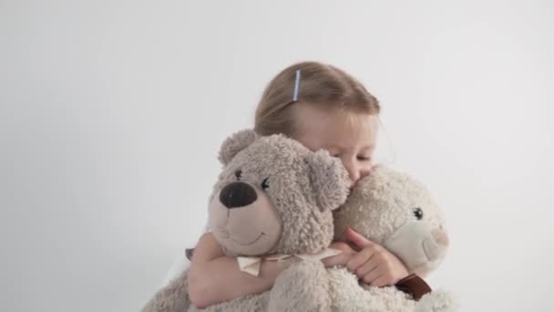 Una hermosa niña juega con osos de peluche — Vídeos de Stock