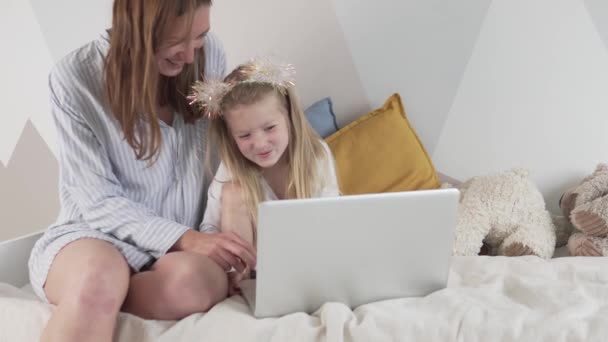 Η μαμά και η μικρή της κόρη διασκεδάζουν με τον υπολογιστή στο σπίτι. — Αρχείο Βίντεο