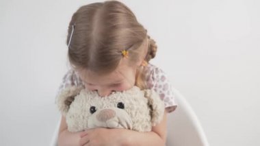 Güzel küçük bir kız beyaz bir ayıya sarılıyor.. 