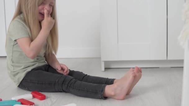 En söt liten flicka gråter på grund av det fallna tornet spelet — Stockvideo