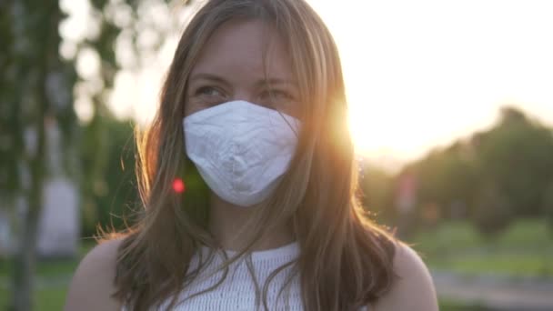 Крупним планом красива жінка в масці на її обличчі на заході сонця — стокове відео