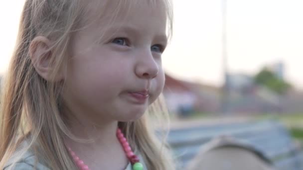 Close-up van de schattige kleine meisjes schattige baby op een wandeling in het park in de zomer — Stockvideo