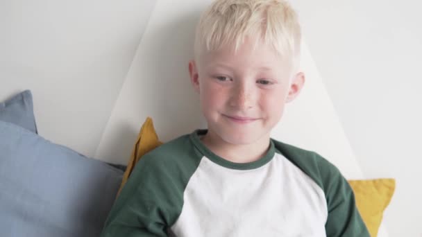 En snygg blond pojke bär glasögon med en ockluder för att rocka utsikten över det lata ögat — Stockvideo