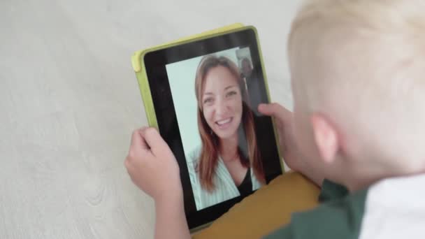 Bir gencin oğlu annesiyle tabletteki video bağlantısıyla iletişim kuruyor. — Stok video