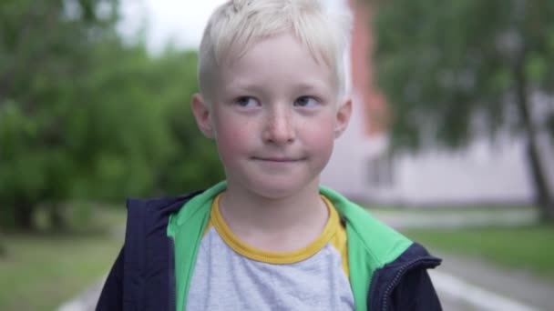 En närbild av ansiktet på en stilig tonåring albino pojke på en promenad efter självisolering — Stockvideo