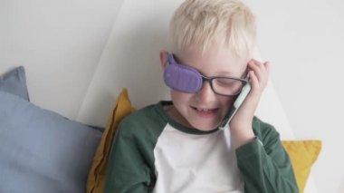 Gözlüklü, gözlüklü, cep telefonuyla konuşan genç bir çocuk.