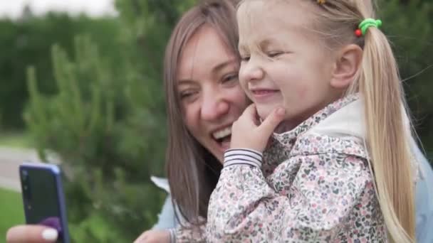 Máma a dcera se spolu vyfotí po telefonu. — Stock video