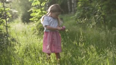 Küçük bir kız elbise cebinde bir gül saklar..