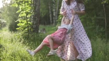 Anne ve kızının alevli günbatımında dönmeleri ağır çekimde.