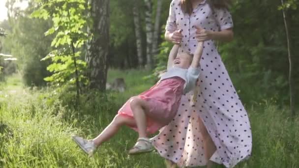 Медленное движение матери и дочери, вращающихся в ярком закате — стоковое видео
