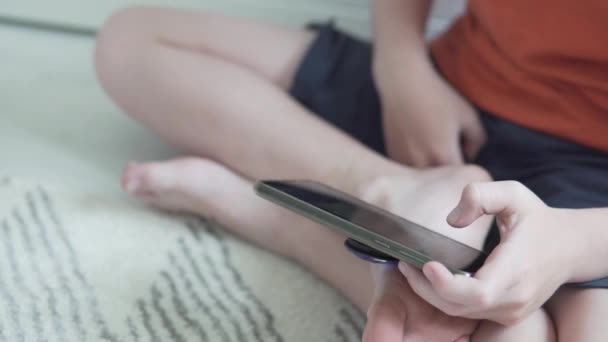 The child uses a mobile phone, a close-up of the hands — Stock Video