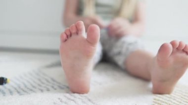 Childs 'ın ayaklarının yakın plan çekimi evin tasarımcısını canlandırıyor.