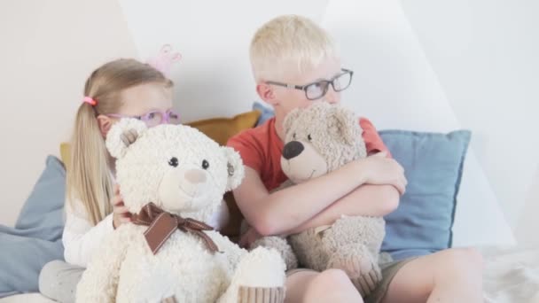 Niedliche Kinder in Brillen umarmen Spielzeug-Teddybären — Stockvideo