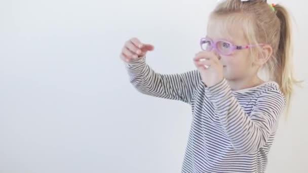 Seorang gadis kecil berkacamata menari lucu dengan musik — Stok Video