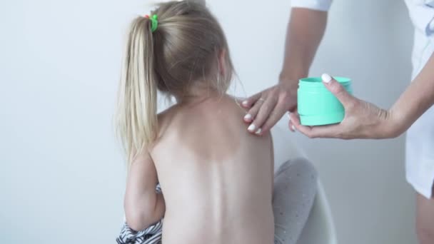 Der Arzt reibt die Körpercreme in den sonnenverbrannten Rücken — Stockvideo