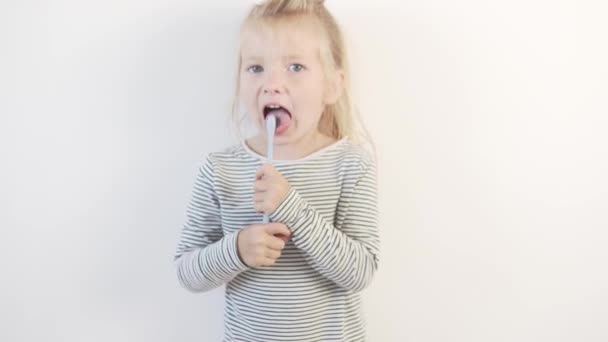 Funny little girl brushes her teeth with a toothbrush — Stock Video