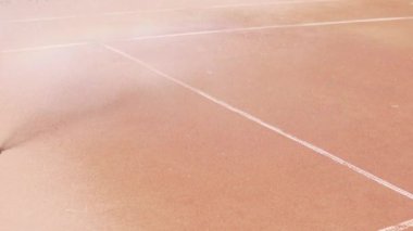 Sokakta tenis oynamadan önce toprak tenis kortunu sulamak..