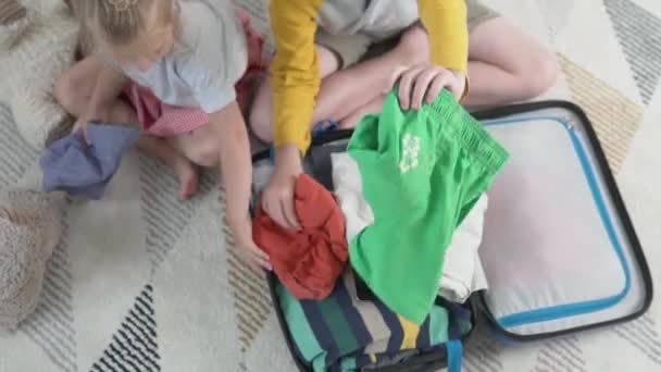 Die Kinder packen ihre Koffer im Urlaub — Stockvideo