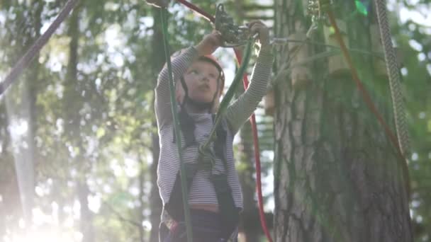 Malá holka pohne karabinou na laně v provazovém parku — Stock video