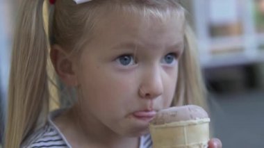 Güzel küçük bir kız dondurma yiyor..