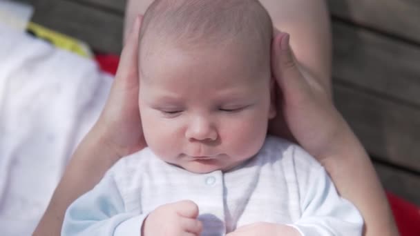 Close-up van schattige baby jongen in moeders armen — Stockvideo