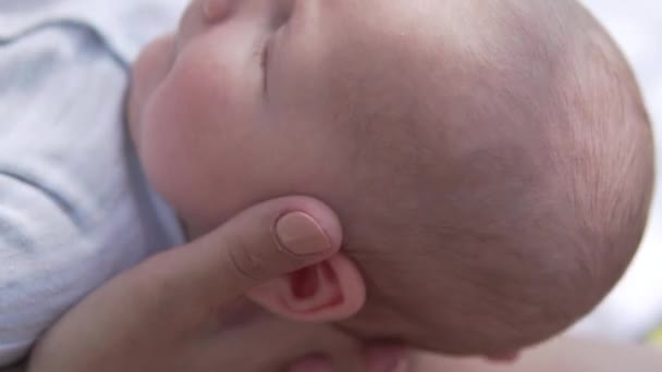 Las manos de las madres sostienen la cabeza del bebé recién nacido en un paseo — Vídeos de Stock