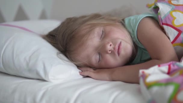 En vacker liten flicka sover sött i sin säng — Stockvideo