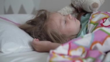 Tatlı küçük kız yatağında uyuyor.