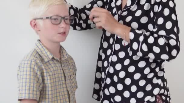 Mãe penteia o cabelo de um menino de escola de manhã — Vídeo de Stock