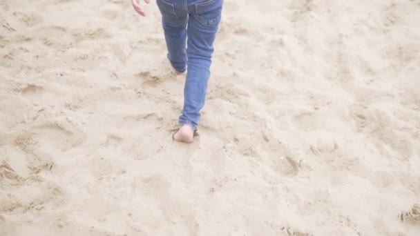 ジーンズの子供たちの足は砂の上に行く — ストック動画