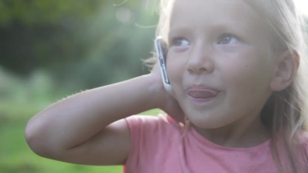 Mała dziewczynka rozmawiająca przez telefon komórkowy na spacerze w mglistym lesie. — Wideo stockowe