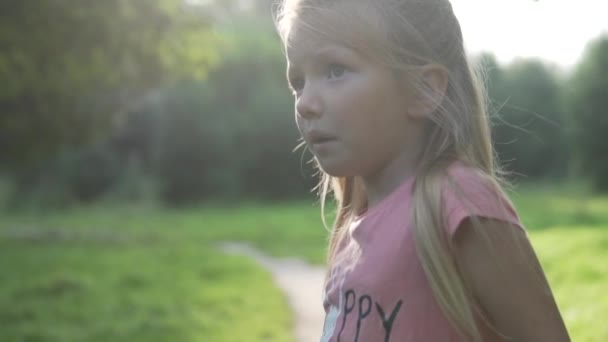 Närbild av en vacker flicka i en sommarskog — Stockvideo