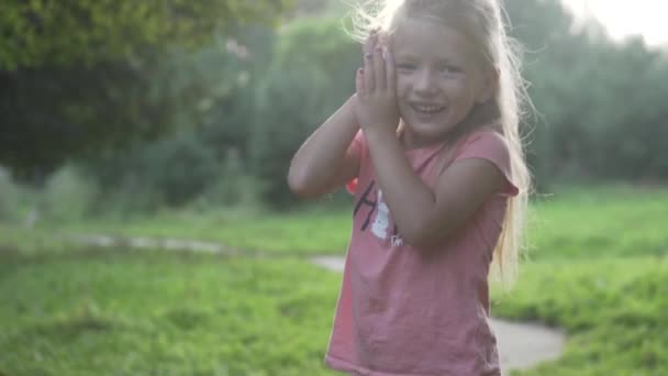 En liten flicka som pratar på en mobiltelefon på en promenad i en dimmig skog — Stockvideo